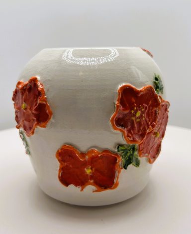 White clay base, slip made flowers, hand painted colors. Jungle Gem internal glaze. Clear glaze coating. Measurements: D-4in.x H-4in.