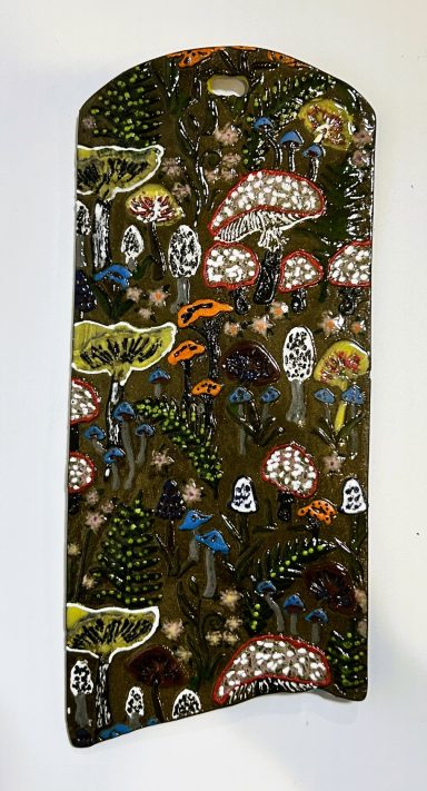 Dark clay base. Textured hand painted wall hanging. Clear glaze cover. H-10.25in x 4.25 in.