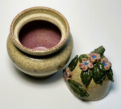 Speckled clay body. Hand painted vessel details. 3D flower hand painted appliques. Lavender glaze interior. H-6in x W-4.5in.