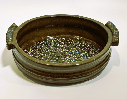 Dark clay base. Serving dish with handles. Intricate hand painted details to bottom, handles, and feet. Clear glaze. H-3inxW-7.25inxL-9.5in.