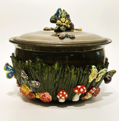 Dark clay base. Lidded Pot. Hand painted porcelain butterfly garden themed appliques. Clear glaze interior. H-6 1/8in x Diameter-7 3/8in.