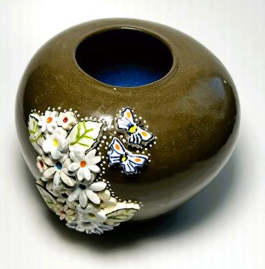 Dark brown clay base. Hand painted porcelain flower and butterfly appliques. Royal blue glaze interior. H-5in x W-6.5in.