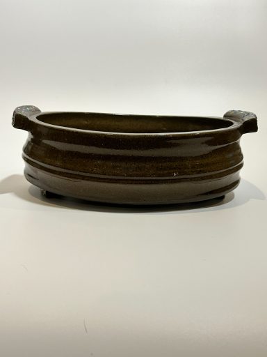 Dark clay base. Serving dish with handles. Intricate hand painted details to bottom, handles, and feet. Clear glaze. H-3inxW-7.25inxL-9.5in.