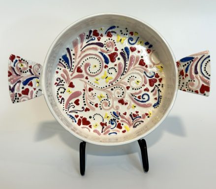 White clay base. Textured hand platter with handles and heart feet. Hand painted. H-3in x Diameter-6 3/8in.
