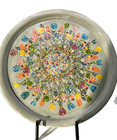 White clay base with grey underglaze color, hand painted flowers cover the top, clear glaze coat. Measurements: D-9.75in.