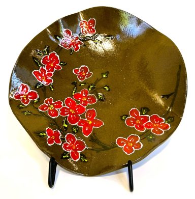 Dark brown clay base. Wavy surface. Hand painted flower detail. Clear glaze cover. Diameter-11in.